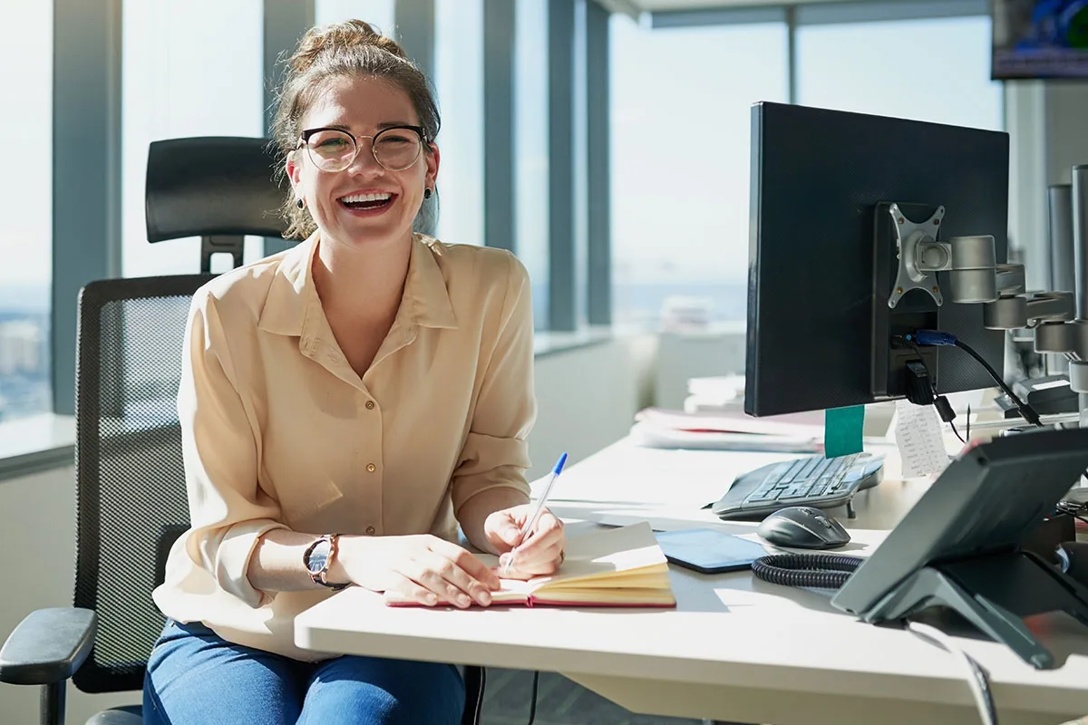 Female worker laughing and taking notes